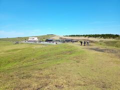 広々した草千里。
駐車場の方を振り返って写真撮影。
1番左側の白い建物が、阿蘇火山博物館。