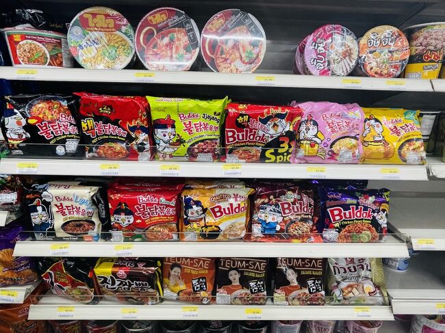 ちょっと歩くとすぐに熱中症になりそうで、早々にセブンに避難。<br /><br />本国をも凌ぐブルダックポックンミョンの品揃え。<br />もう韓国じゃほぼほぼ手に入らない元祖の方のチャジャンミョン＜黄緑＞や、日本限定かと思われたYakisoba＜茶色＞まである。<br /><br />そして、右下のヤツ！