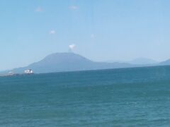 錦江湾をずっと見ていました。
１時間くらいの乗車時間ですので、飽きずに見ていることができました。
桜島が見えてきました。
噴煙が出ているようですな。