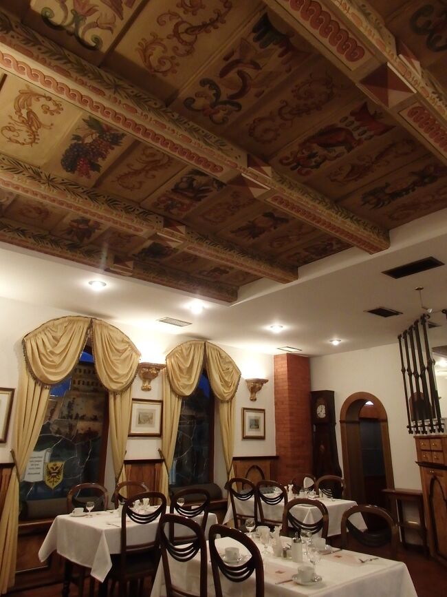 ホテル・ロイヤル・リックの朝食ルーム<br /><br />天井には素敵な装飾があり、ステンドグラスが施された窓周りのカーテンもゴージャスな感じ