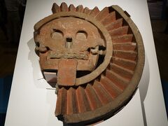 「死のディスク石彫」テオティワカン文明 年550～300、太陽のピラミッド、テオティワカン太陽の広場出土 メキシコ国立人類学博物館
メキシコ先住民の世界観では太陽は沈んだ（死んだ）のち、夜明けとともに東から再生すると信じられていました。この作品は地平線に沈んだ夜の太陽を表わすと考えられています。復元すると直径1.5mにもなる大型の石彫です。
