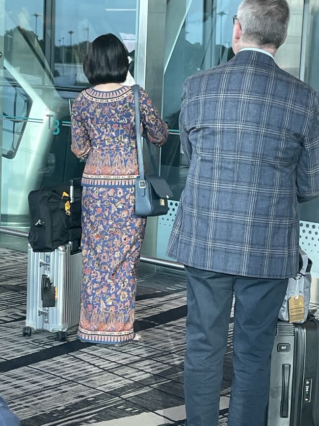 搭乗時間も迫って来たので、スカイトレインで第2ターミナルへ移動。<br />乗り場でシンガポールエアラインのCAさんが立っていたのでパチリ。<br />ユニフォームのサロンケバヤ姿が美しい。<br />後ろのオジ様も、チラ見しているような？