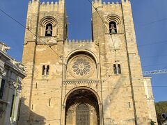 大聖堂(Santa Maria Maior de Lisboa)に到着したのが不覚にも6:40pm。扉はすでに6:00pmで閉まっていた。リスボンで一番古い教会（1147年建築スタート）であるし、美しい内陣天井やユニークなバロックスタイルのパイプオルガンを見たかったのだけど、次の機会にするとしよう。
華やかなバラ窓を正面に持つロマネスク様式だが、要塞教会として建設されたため、非常に重厚感がある。天辺が鋸壁になっている側防塔―Fortified Tower―＞鐘楼を特に巨大化させて天守の役割を持たせている。防御のために入口や窓の設置も採光を犠牲にしても極限まで抑えてある。色と材質が異なる正面石壁は度重なる地震のあと、修復、強化された部分であることを物語っている。この教会が体験してきた歴史を目の当たりにするようだ。

