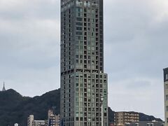 屋上にヘリパッドがある建物の31階に、門司港レトロ展望室があります。

この建物は、建築家　黒川紀章氏設計の高層マンションで、高さ103mから関門海峡や門司港レトロの街並みを見渡せる絶景ポイントとなっています。

この建物は、景観を巡り裁判で争われ、最終的に市が最上階の31階を買い取り、「門司港レトロ展望室」として観光用に開放する事で決着したようです。

当初は、15階建てのマンション計画を、規模や形態が景観保全をめざす地区にそぐわないとして、都市景観条例に基づいて計画を見直すよう行政指導が行われ、外観をレトロ調に改めたようですが、基本的な形態は変わらなかった為、市は建築確認を行わなかった事で、不服とした建築主が提訴し「マンションの幅を狭くして高さを倍にする」という形で法廷では決着したようです。

市が問題としたのは、約50mという高さにより、景観上重要な和布刈山が船だまりから見えなくなる事で、横幅を狭くすることで山を見えるようにし、高さを高くしてマンションの容積を確保したという妥協の産物のようです。

景観と言うなら、門司港レトロにはそぐわない景観かなと思いますが、京都タワーを比喩した、「京都で一番景色が良いのは、京都タワーの展望台。だって京都タワーが見えないから。」と一緒かなと思います。