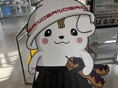佐野駅では、市のキャラクター『さのまる』がお出迎え。
かぶったラーメン丼の雷紋は『SANO』と書かれている。
丼から垂れた前髪は麺、腕にはこれも佐野名物のいもフライを抱えている。