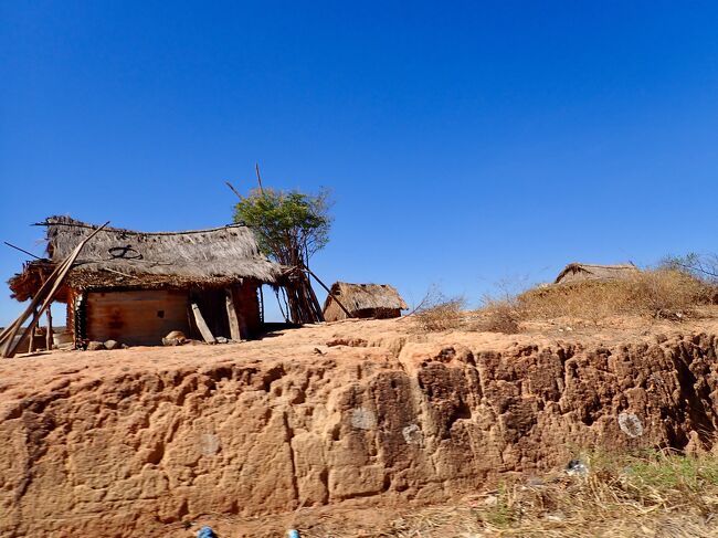 こちらの家は、藁の屋根に干しレンガ。<br />赤い大地の上に立っています。