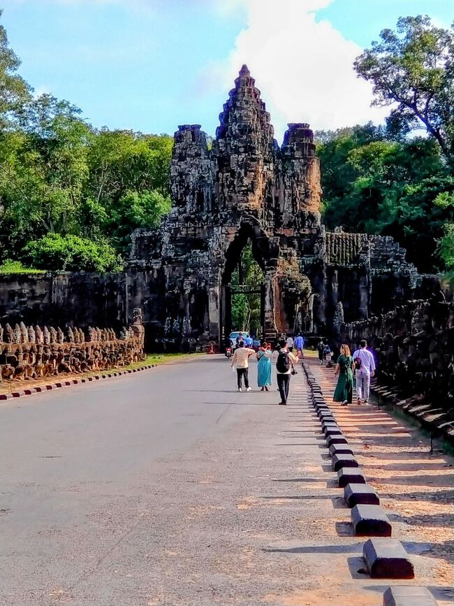 いよいよ最終日の観光スタート！<br />ホテルを８時出発しました。アンコールワットの駐車場で、マイクロバス２台に分かれて乗り換えます。アンコール遺跡内は、大型バスは運行できないのです。<br />８時２０分、本日最初の訪問地「アンコールトム」に到着しました。昨日訪問した「アンコールワット」のすぐ北にあります。<br /><br />アンコール・トムは12世紀後半にジャヤーヴァルマン7世により建築された王都で一辺が3kmの堀と、高さ8mの城壁に囲まれています。アンコール遺跡の中でも、けた外れの規模を持ちます。<br /><br />南大門に到着。<br /><br />橋の左右にはたくさんの像が並んでいました。