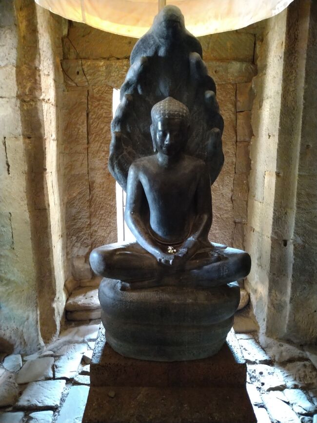 他の塔の中に飾られていたカンボジアの仏像。<br /><br />ポリンさんがこの仏像にまつわる面白い逸話を話してくれました。<br /><br />ブッダが瞑想していたところ大雨が降ってきたので、蛇神ナーガが頭を傘のように広げてブッダを守ったという説話に基づいた像だそうです。<br /><br />ナーガのとぐろを巻いた体を台座にして、７つの頭をさしかけてブッダを守る様子をあらわしたこのような仏像はカンボジアで多数作られているそうです。<br />ヒンズー教の神ナーガと仏陀のコラボ。面白いです。
