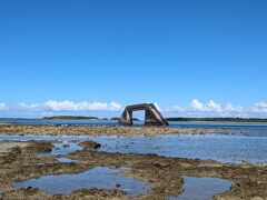 シールガチ橋への道

16時35分
干潮時にしか渡れない、幻の橋「シールガチ橋」にやってきました。

この橋、観光スポットでは無いので、きちんとした案内がありません。
Googleマップを見ながら行ったり来たりしました。

行き方は、イーフビーチ方面から行く場合、奥武島へ渡る道へ右折せず、まっすぐ久米島一周線を走ります。
数分走ると、車エビ養殖場・販売所の看板が見えるのでそこを入ります。

工事現場の様な舗装されていない道なので、一瞬戸惑いますが迷わず進みましょう。
金網で囲われた養殖場の手前で車を停め、降りて海の方を覗くと、海に出る草道が見えます。

写真は草道を抜けた海岸の様子です。
ここから写真右端に見える橋まで歩きます。

かなり歩きづらく、ぬるぬる！なので靴底のしっかりした靴がお勧めです。
サンダルとかマリンシューズだと大変です。