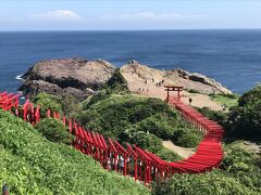 午前９時過ぎ、元乃隅神社に到着。

元乃隅神社（旧称　元乃隅稲成神社）は、商売繁盛、良縁成就、子宝、開運など様々なご利益のある神社だそう。近年、123基の赤鳥居が青い海原に向かって並ぶ絶景のインスタ映えする神社として人気急上昇の神社。
この神社は、神社としての歴史は浅く、昭和30年に地域の網元であった岡村斉（おかむらひとし）氏の枕元に現れた白狐のお告げにより建立されたとのこと。
つまりこの神社は、宗教法人格は保有していず、神社本庁等にも帰属していないあくまでも個人の所有物であるとのこと。

ここに来るまでの道路は全く混んでいず、第一駐車場もまだ余裕で空いていた。
一方で、もっと早く来ている人たちもいて、既に見学を終えて帰られる人たちもいた。

３０分余り滞在したが、９時４０分ごろには神社すぐ横の第一駐車場（１時間３００円、最大５００円）はかなり満車に近かったので、休みの日などにここに来る場合は、やはり９時過ぎくらいには着くようにした方がよさそう。
