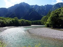 右手に見える梓川の美しい川の流れ。後方には六百山などが連なる山々が控えています。