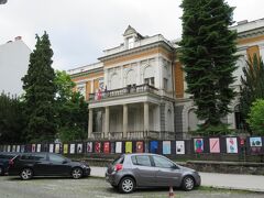 マリボルには、旧市街地の美しい街並みのほか、ナチスに占領された第二次世界大戦～抵抗運動によって解放を勝ち取るまでの歴史を多数の展示品で紹介している博物館もあります。

マリボルでのお宿になったCASA PARK PREMIUM free parkingとはムラディンスカ通りを隔てたお向かいにあるNational Liberation Museum Maribor（直訳すれば、マリボルの民族解放博物館）がその博物館。

風格ある黄色い建物で、周りを囲むフェンスにはその時々のイベント予告ポスターなどが多数出ていてすぐ分かります。
マリボルの歴史に興味のある方は来てみるといいですよ。
何と、朝8時から開いています。