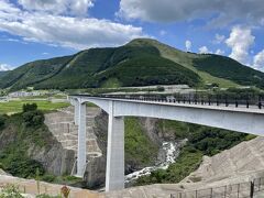 2021年３月に開通した、新阿蘇大橋（全長525m、最大橋脚高97m）のたもとにある展望所に立ち寄りました。真正面に見えているのが新阿蘇大橋。こちらも熊本地震で崩落したのが、やっと復旧したんですよね。
