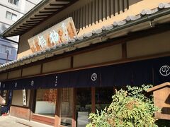 【鶴屋吉信 本店】
https://www.tsuruyayoshinobu.jp/

京都府庁旧本館から堀川通に出て，バスで堀川下立売から堀川丸太町へ。堀川通は市バスの幹線ルートのひとつだけあって，バスの本数が多い。鶴屋吉信でおやつを仕入れます。

欅の一枚板の大看板には「柚餅（ゆうもち）」と書かれています。富岡鉄斎(1837-1924)の揮毫（きごう）。京都御苑の中立売御門の近く，室町通一条下ルには，鉄斎の旧宅が残っています。