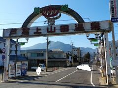 上田駅から約２０分。目的地の戸倉駅に到着した。
予定の列車に乗り遅れたため、４０分遅れでの到着。川を挟んで駅側と川向うに日帰り入浴施設が合計７つ。すべて入浴する予定だ。
こちらは戸倉駅前。アーチ状の看板が昭和レトロ感があり味わい深い。