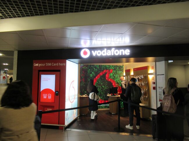 今回は、荷物は預けずに機内持ち込みできるサイズのキャリーケースとバックパックで移動時間を短縮です。なので、バゲッジクレームを素通りして出口に向かいます。<br />到着ゾーンを出る前にボーダフォンのショップがありました。