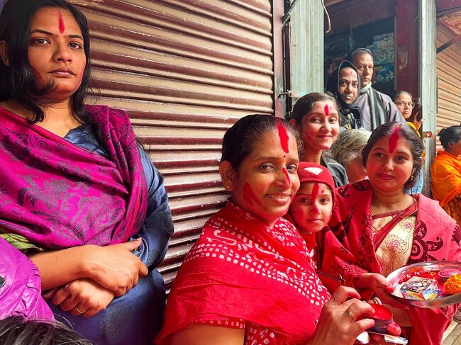 控えめな女性陣は路地の端で見学していました。<br />私もあの赤いパウダーを額に付けてもらいました。