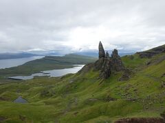 １１．スカイ島②オールドマン・オブ・ストーとキルトロック

・スカイ島はハイランドの魅力をギュッと凝縮した島。その中でもOld Man of StorrとKilt Rock Waterfall はその双璧。スカイ島のTV番組や写真には必ず登場するスポットである。
・Old Man of Storrは55メートルの孤高の巨岩で、28億年前の火山栓の残骸が地滑りで現在の場所まで運ばれたもの。最初からひたすら登りが続く。初めは雲に隠れていたStorr山が見えて、高度を上げるごとに360度の素晴らしい展望が開けて行った。きつい1時間半の登りでStorr Lookout Pointに到着。Old Man of StorrとNeedle Rock、背後にレザン湖とラッセイ島、海峡の向こうにイギリス本土。写真で何度も見た憧れの眺望に感動していたら５分もしない内に雲に隠れてしまった。下山中に再び雲は切れたがスカイ島の天気の変化は目まぐるしい。
・Kilt Rock Waterfall 展望台に着いた時は激しい雨と風。断崖から垂直に落ちる滝を撮るには展望台から思い切り腕を伸ばさねばならない。雨に濡れながら柵から上半身を伸ばし、カメラのレンズを拭き拭き落とさないよう必死に撮影した。今思うとスマホを落とさずよかった。この辺りでは多くの恐竜の化石が発掘されており、博物館もあった。北緯57度の場所も大古は温暖だったのだろう。博物館を出ると青空が出ていたのでもう一度写真を撮りに行った。
・昨日のFearly Poolを含めスカイ島の大自然を自分の足で歩けて良かった。ツアーが中止になったのは結果的に大正解。スカイ島は他にもQuiraing walkやNeist Point等の雄大な風景を見れる場所があり、本来ならあと1泊したかった。しかし安宿を確保できず、明日は日曜日で島のバスは運休になることを考えると、未練を残しながら去るのが賢明か。

　写真：オールドマン・オブ・ストー
　旅行記はここ→　https://4travel.jp/travelogue/11880176