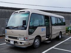 バス停から少し歩くと、市営の駐車場に着いた。そこが、椿まつりの期間中、会場へと向かう無料のシャトルバスの発着場となっている。案内の人も時刻表すらも無いので、仕方が無く、立っていた幟の近くで待つ。すると、しばらくして、シャトルバスがやって来た。