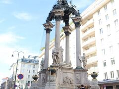 「アンカー時計」は、ウィーン最古の広場「ホーアーマルクト広場」にあります。
この広場は、今のウィーンの原型である古代ローマ帝国の時代に置かれた都市「ウィンドボナ」の中心地だったところで、古代はドナウ川がすぐそばを流れていて、そのドナウ川が帝国の境界線だったそうです。その後、13～14世紀は交易の中心地になり、処刑場やさらし場としても19世紀まで使われていた場所です。

そんな由緒ある広場の中心に、とても立派な噴水があります。バロック様式の美しい噴水で、「結婚式の噴水」と呼ばれています。が、なんと絞首台跡に建てられているそうです。

そもそもは、レオポルド1世が、戦地に赴いていた長男のヨーゼフ 1 世の必勝祈願で、生還したら聖ヨセフの記念碑を建てると誓っていたことから造られたもので、当の本人が建設よりも前に亡くなってしまったので、生還したヨーゼフ自身がバロック建築の巨匠「フィッシャー・フォン・エルラッハ」と共同で設計、建築した木製の記念碑が1707年に建てられたそうです。

この記念碑を立てるために絞首台を撤去したので、それ以降ここで処刑は行われなくなったそうです。

【Hoher Markt】