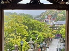 　本殿からの眺め。雨に洗われた緑と寺院の赤のコントラストが美しい。

　この後、大雨の中、傘を差して信貴山山頂にある空鉢護法堂まで登ったのですが、霧で曇って何も見えず。空鉢護法堂は縁起絵巻の飛倉のエピソードに由来するお堂で、本堂から坂と階段から成る700mの参道を登っていった山頂にあり、天気が良ければ奈良の街を見下ろす絶景を拝むことができるそう・・・残念！

　空鉢護法堂には社務所があり、ご担当者にいろいろと興味深いお話をお伺いすることができました。大晦日から元旦にかけては、奈良盆地から昇るご来光を拝もうと多くの人出となるそうです。

　空鉢護法堂から戻る道で「開山堂」に立ち寄りました。四国に行くことなく四国八十八ヵ所巡りをここで一度にできるのですが、巡る順番や置いていくお札、唱える真言などに決まりがあり、説明をしっかり聞いて集中して行わないと最後にお札が余ったり足りなかったり・・・。
　
　ここでユーモアを交えて早口だけど丁寧にご説明下さったご担当者は、噂によると信貴山開山堂の名物おばさん(「オバチャン」という方がしっくりくるかも？)だとか。お祈りをしていると、後ろから「あんた、ちゃんと真言唱えてるか～？　手抜きはあかんで！」などと助言？を下さるので、どこまでお祈りしたか判らなくなり、最後にお札が1枚残ってしまいましたｗ　この時お参りをしたのは私たち2人だけでしたが、2月22日の聖徳太子の御遠忌には数十メートルの行列ができるほどの混雑具合だそうです。

※空いていたおかげで「オバチャン」との会話を楽しめました！ありがとうございましたｘ