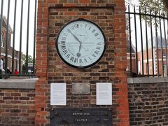 丘を登ること5分ほどで、「グリニッジ天文台」の入口にある「グリニッジ標準時」を示す「シェパード・ゲートクロック」に到着です。
小学校の時から知ってましたよね「グリニッジ標準時」

この時計は、1852年に「チャールズ・シェパード」によって構築・設置された時計で、グリニッジ標準時を一般に表示した最初のものだそうです。24時間のアナログ文字盤を使用し、当初は真夜中ではなく正午から始まる天文時間を示していたとのことです。
24時間表示なので、ちょいとわかりにくいですが、13:53を指しています。カメラの時計誤差無し！

「グリニッジ天文台」は、1957年にロンドンが明るすぎて星が良く見えなくなったことから、イースト・サセックスのハーストモンソーに移転し、ここは「グリニッジ旧王立天文台」となりました。その後移転先の天文台が閉鎖されたため、再びここが「グリニッジ天文台」と呼ばれるようになったそうです。ただし、今はここに観測機器はなく、史跡として残されています。