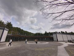 ミホミュージアムへは、信楽駅からバスを利用しようと考えていました。
しかし当日の朝、再確認でバスの時間を調べたところ、乗る予定だった時間のバスが消えてました…４月に入りダイヤ改正があったと思われます。
急遽予定を変更し、石山駅からバスに乗ることに。
このバスも４月から料金値上がりしていました。

石山駅のバス停は長蛇の列だったのですが、バスが来たとたん、列の後ろに並んでいる人が我先にと順番抜かして乗ろうとするのにびっくり…。
臨時便を出してくれたので、順番抜かして乗り込んだ人は立ったまま５０分、ちゃんと待って後ろのバスに乗った人は全員座れました。

残念なスタートで嫌な気持ちになったけど、バス停にいた案内係の女性が元気に対応していたり、バスが出発すると手を振ってくれたりして、心が和みました。

ミホミュージアムに到着し、まず現れるのはレセプション棟。
ここでチケットを購入、レストランもありました。