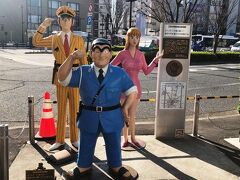 《亀有駅南口前》「ようこそこち亀の街へ！両津・中川・麗子がお出迎え！像」…亀有駅南口を出ると目の前に「ようこそ こち亀の街へ！両津・中川・麗子がお出迎え！像」があります。「両さん」はポパイならぬ力こぶをつくり、亀有の案内は俺に任せろと言っているような感じです。