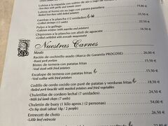 マヨール広場のすぐ近く、ガイドブックにものっているレストラン「El Sitio」にきました。時間は13時半ころ。
予約をしていなかったのですが、ぎりぎりバルとの境目の二人掛けスツール席に着席することができました。夫はすぐに奥のトイレにw

メニューです。
子豚の丸焼き（ポーション）は頼むとして～。