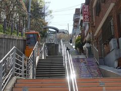 　道の向かい側の階段に並んで走るのが、第１の目的地・瀛州洞（ヨンジュドン）オルムキルモノレールです。傾斜地での生活改善のため、釜山市の中区が設置しました。
　モノレールとはいっても法律で定められた正式な鉄道ではなく、昇降設備の一種。日本でも、この規格の乗り物は同様の扱いです。
