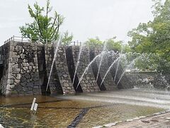 石垣のような壁から水が放水されています。