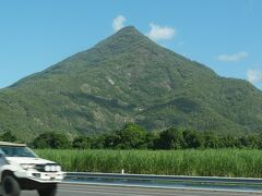 ホテルに戻って、午後３時に迎えの車が来て出発。
途中、何か所かでピックアップして１０人ほどでスタート。
パロネラパークまでは約１００キロ。

途中右手に見えてきた山はその形から「ピラミッド山」と呼ばれているそうです。
左手には日本のローカル線のような単線、非電化、狭軌の貧弱なレールが並行していましたが、これがケアンズとブリスベンを結ぶ鉄道。
今は１日１往復、ケアンズとブリスベンを２４時間かけて走る観光客向けの寝台列車だけのようです。