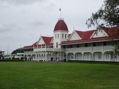 トンガの王宮（１８６７年に完成した王宮で、白い壁と赤い屋根で旗がある時は国王が滞在しているそうです。後方にサイオネ教会は国王が通う。２０１５年７月の国王トゥポウ６世の戴冠式には今の天皇皇后両陛下（当時は皇太子）が参列した。）