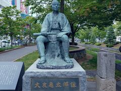 大友亀太郎像
【札幌開拓の先駆者、1834年小田原生まれで、二宮尊徳の門に学び「人の一生は金銀財宝に富めるにあらず　積善の道に如かず」を信念とした。
1866年函館奉行に蝦夷地開墾の計画書を提出、札幌市東区を開墾。
亀太郎が掘った大友堀は今日の創成川の基となって、街の中心部を流れ続けている】
ざっとこんな感じの説明書きあり。
右手に握っているのは望遠鏡かな？
