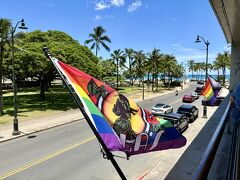 【 Hula's Bar & Lei Stand @WAIKIKI GRAND 】
https://hulas.com/
https://www.waikikigrandhotel.com/

ハワイ到着日，アロヒラニリゾートでは13時までに部屋を用意してくださるとのことで，近くのバーへ飲みに行くことにします。

カパフル・アヴェニューに面するワイキキ・グランド・ホテル2階の【フラズ・バー&レイ・スタンド】。ホノルル動物園のあるカピオラ二・パークの緑を見下ろし，ダイヤモンドヘッドからワイキキビーチまで見渡せるオープンエアのバー（ていうか窓にガラスが嵌まってない）は，ワイキキ広しと言えどもここだけでしょう。

写真右寄りのビーチの先に，クヒオビーチ（右手・西側）とクイーンズビーチ（左手・東側）を分けるカパフル防波堤（通称ワイキキ・ウォール）が見えています。