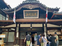 外観をぐるりとまわり正面へ。
玄関右側がチケット売り場です。
一部の貸切部屋以外は（定員が10人以上の大広間）事前予約ができないので、待ち時間があるかないかは運次第。

ちなみに、道後温泉の公式ホームページで「道後温泉3館 待ち時間／利用状況」が確認できるのでこれを見て動くと効率的☆
　　↓　↓　↓
https://dogo.jp/#waiting