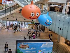 スタンプラリーイベント「ドラゴンクエストカーニバル in 横浜・みなとみらい」（期間は2024年7/20(土)～8/18(日)）。

マークイズにて。ここでもスタンプラリーのスポットが３箇所あり。続いて２階のスタンプスポットに回ります。２階から見下ろすと、先程のキングスライム像と、３色のスライムタワーが観えます。
キングスライム像の地面はゲーム画面のフィールドのデザインになっています。

２階のスタンプスポットの壁絵は、ロープウェイ「ヨコハマエアチェイン」とドラクエとがコラボしてました。
