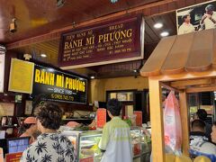 朝ご飯がゆっくりだったので，お昼ご飯も14時近くに。
こちらのBanh Mi Phuong（バインミーフーン）というお店。
なにやらベトナムで一番おいしいバインミー屋さんなんだとか。
確かに入口はとっても混雑。
何も知らないとココで頼んでしまうんだけれど，実は店内1Fも2Fもイートインスペースで，そこでオーダーができます。