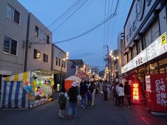 梁川通りに露店が並びます。
右側に見えているのは、鶏の半身揚げで有名になった「なると」。