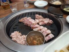 焼肉は豚のサムギョプサル（３枚バラ肉）とモクサル（首回りの肉）の２種類。孫４人、大人７人なので８人前ほど注文したが、どちらも評判通り美味かった。特にモクサルは日本にはない部位だそうで、言うことなし。ビール、韓国焼酎が進んだ。写真はサムギョプサル。