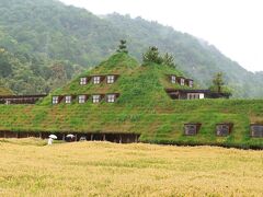 新横浜から新幹線で米原まで行き、米原からJR琵琶湖線で近江八幡へ（トータル約２時間半）。
近江八幡駅に着いたころから雨がザーザー降りに。ううむ、今日訪れるところは屋内ばかりだけど、やはり雨は残念……。

近江八幡駅からタクシーに乗り、途中、本日宿泊するお宿〈旅籠八〉に立ち寄って荷物を預かってもらい、〈ラコリーナ近江八幡〉へ。
（※近江八幡駅からラコリーナへタクシーで真っすぐ行けば10分ちょっと）

ラコリーナはバームクーヘンで有名な「クラブハリエ」のフラッグシップ店。
実は、夫婦ともどもバームクーヘン好き。夫は甘いものはあまり食べないのに、バームクーヘン（と、ロールケーキ）だけは自分で買ってくるほどです。

テレビで見たあの建物！　芝に覆われた屋根は、まさに童話の世界。
ちなみに、これはラコリーナのメインショップです。
