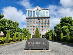 今回の目的地到着
見学の予約をホームページからしておきました。
毎日は開催されていないので合わせるのに少し苦労しました。
そしてもう一つ日本食研製造（株）シェーンブルン宮殿工場も見学したかったのですが、この日はに開催されていなかったので断念しました。
入り口の守衛さんに駐車場の案内と集合場所の説明を聞いて
まずは敷地内の駐車場へ
こちらの建物が今治で2番目に高い建物だと知ったのは後の見学で