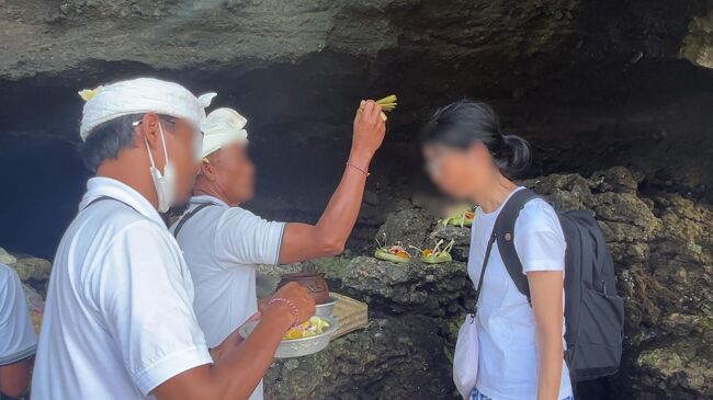 奥さんが神妙な顔をして聖水を頭にかけてもらい、額に米粒（だと思うのですが）を貼り付けてもらいます。有難いことです。<br /><br />さて、時間は既に2時前です。渋滞を考えると他の寺院に寄っていては遅くなるかもしれません。このままデンパサール空港に向かいましょう。<br />