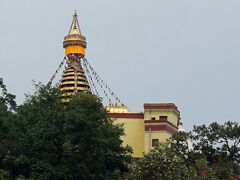 駐車場でバスを降りた後は坂道をだらだら坂を登っていきます。ここから山頂の寺院まではまだかなり登らなければなりませんが、山頂にはストゥーパの一部が見えています。