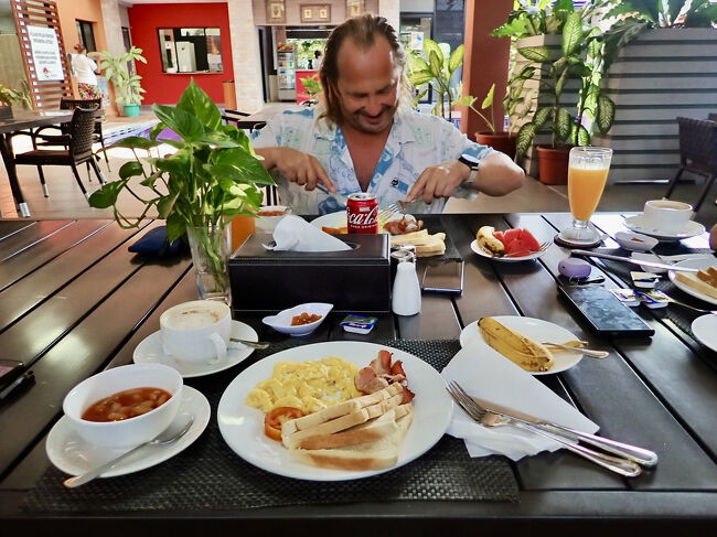 ベイクド・ビーンズとフライド・トマトのあるイングリッシュブレックファースト。<br />対面の彼は満面の笑顔で食べています。<br />(掲載許可済み)