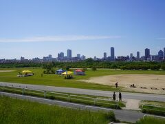 河川敷に出たところが、淀川河川公園 西中島地区。いくつもある淀川河川公園ですが、ここは一番下流の方の公園です。土のグラウンドに周囲の草原とか。眺めは他の地区と同じなのですが、ここの最大の特徴は大阪駅辺りとか、大都会のキタのビル群が淀川の向こうに見えていること。　