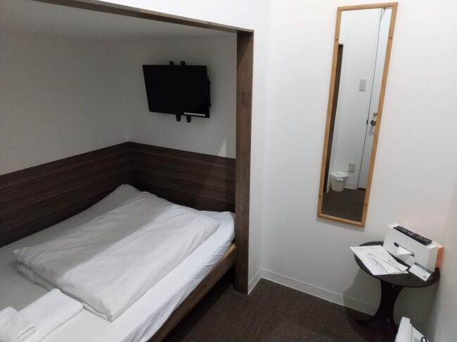 これがそのホテルの部屋です。<br />私の部屋は二段ベッドの下側ですが、上側は隣室の方が使っています。<br />以前、違うホテルで似たような構造のところに泊まったことがありまして、上側は上り下りが面倒だったので、下側を予約しました。<br />下側だと、ちょっとベッドに腰かけたりできるので、やはり便利だと思います。<br />フロントの方には「カプセルホテルに扉がついたような作りですので、音が響きやすいです」言われました。<br />隣の方の物音は聞こえましたが、構造上それくらいは聞こえるよね、と思って過ごしていたので、私は気になりませんでした。