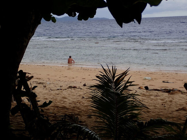 12:25<br />暗い空の下、<br />浜辺で海に浸かっている人がいます。