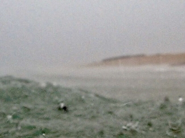 激しい雨に波が泡立ちます。