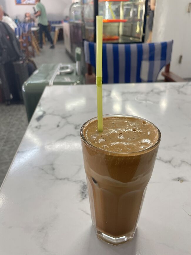 予定より早く港に着いたので、カフェに入って休憩することにしました。<br />ギリシャコーヒーの甘いシェイク？みたいな飲み物だったと思います。<br /><br />1時間ほど休憩して、外に出て船を待つことにしました。<br />待合室のようなところがおそらく船の会社や時間別に分かれているようだったので、チケットカウンターでどこで待てばいいか聞いていきました。<br />待合室は石の建物に石の椅子というか縁石？があるだけのものでかなりの人数が立って待っていました。<br />みんな自分が待っている場所が正しいのか不安だったみたいで、観光客同士で乗る船を確認していました。私たちも前に並んでいた老夫婦の方と確認し、後から来た別の観光客からも確認されました笑<br />石で囲っただけのスペースなのでエアコンなどもなく暑かったです。<br />